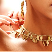 A model with a gold leaf necklace