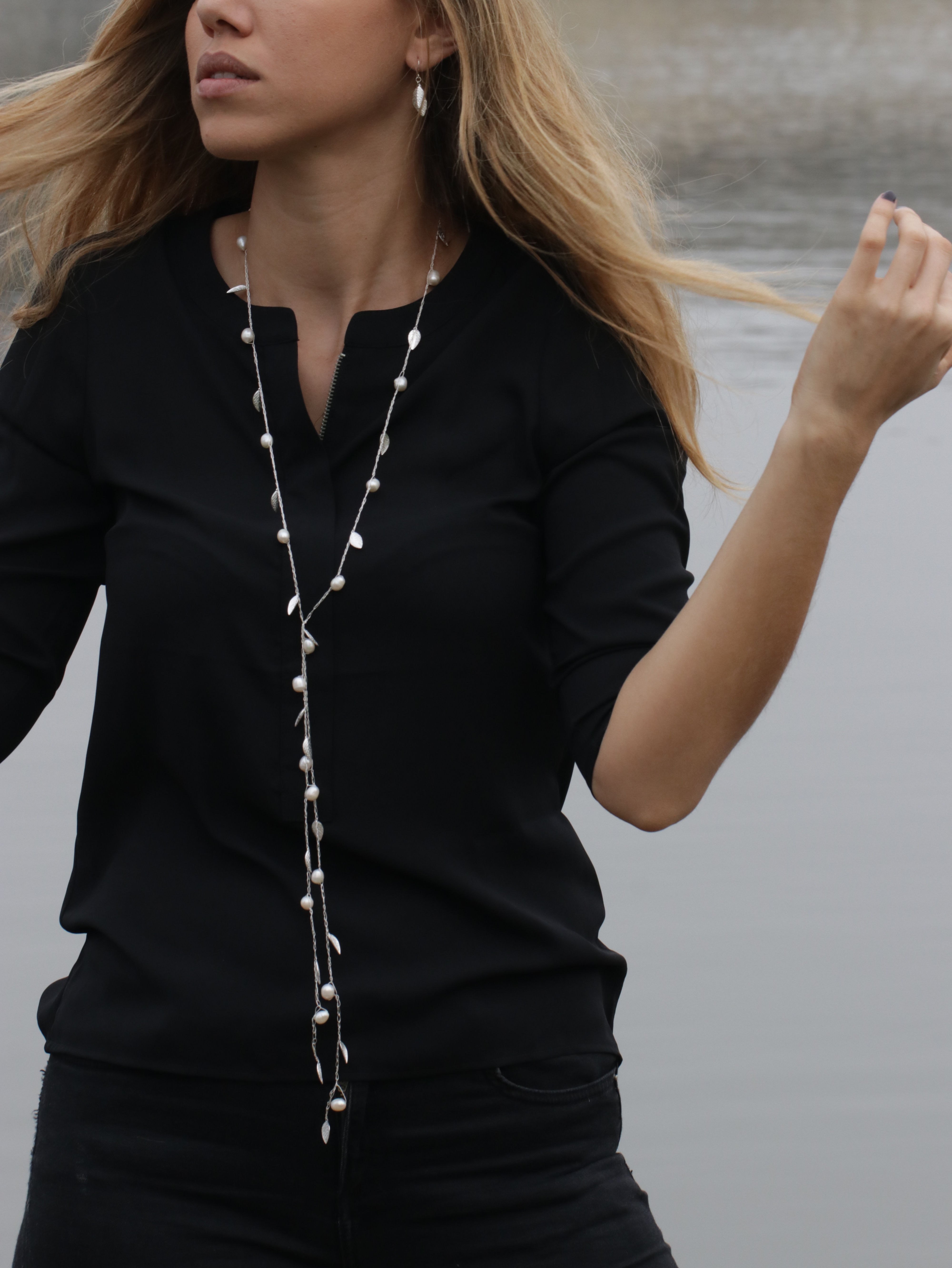A model wears a handmade silver silk necklace with silver leaves and pearls