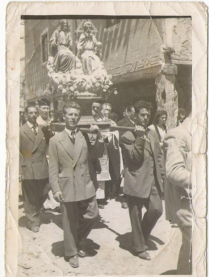 Mozos llevando la imagen de la Santísima Trinidad, por la calle Mayor, seguramente la casa de detrás sea la de Anselmo. En primer lugar, Pepe Yáñez de porteador (si alguien reconoce a alguna persona más, que se ponga en contacto con Darío)