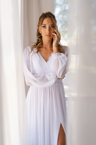 woman standing in white wedding dress for bridal boudoir photoshoot