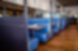 Blue booths and tables in a restaurant with wooden floors and mirrors