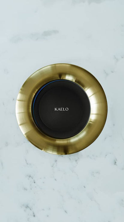 Top down view of brushed Brass finish Kaelo mounted into a granite worktop with Kaelo logo inside 