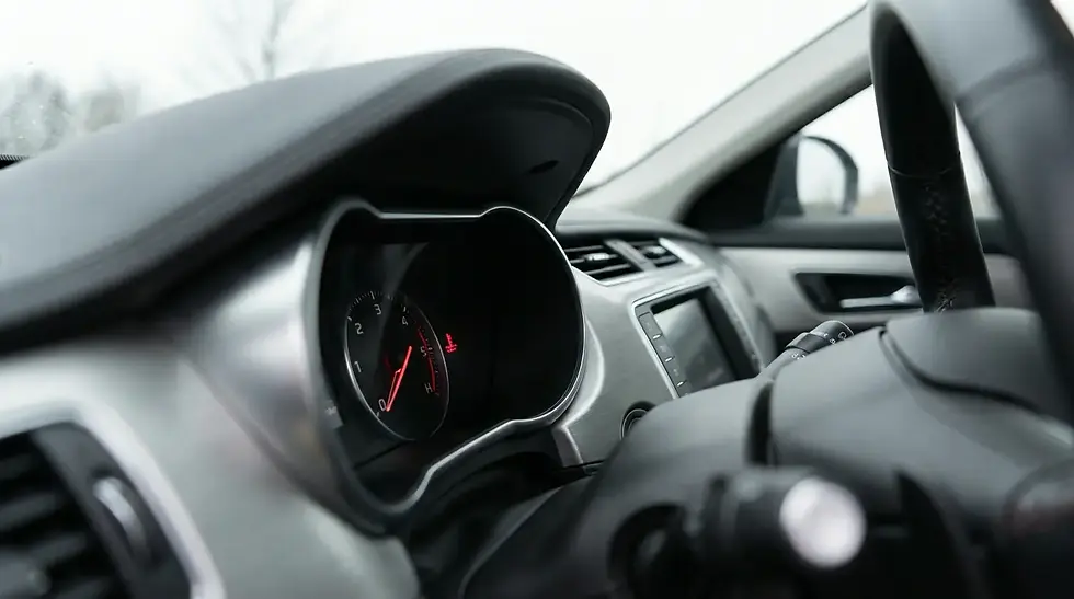 Car dashboard temperature gauge showing needle in red overheating zone with warning light on