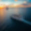 Ariel view of the ocean in during a beautiful sunset - a cruise ship festive and bright is