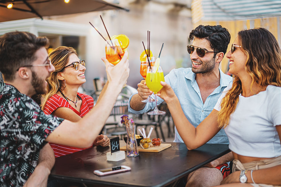 Grupo de amigos sonrientes brindando con cócteles sin alcohol en un restaurante.
