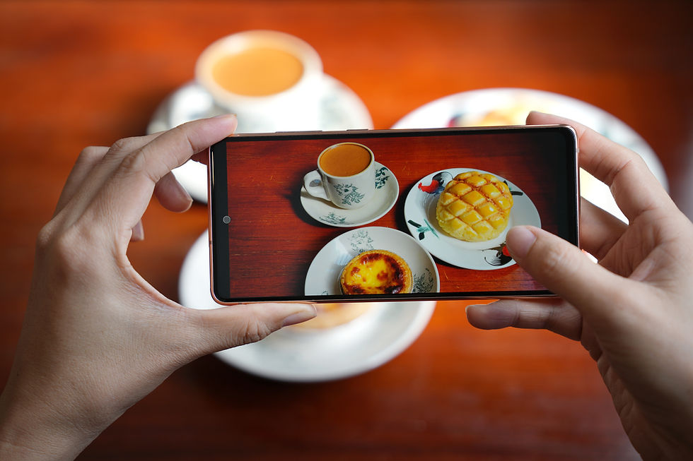 Se ven las manos de ina persona tomando una fotografía de su comida con un smartphone
