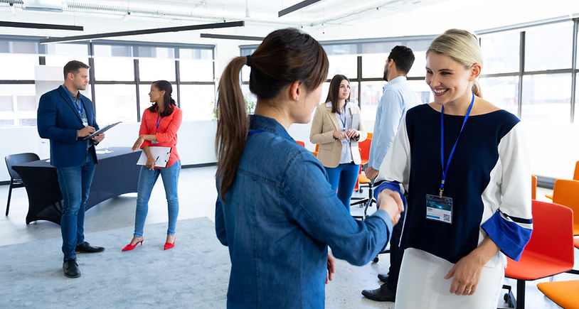 side-view-two-caucasian-businesswomen-working-bright-modern-office-standing-talking-smilin