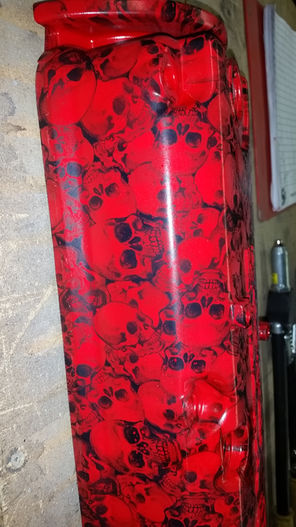 Dodge Ram valve cover painted red with a black skulls pattern finish.