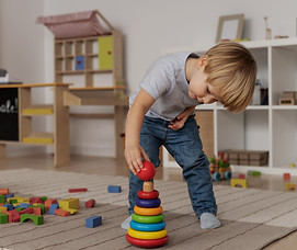 plan complet-enfant-jouant-au-sol-avec-jouet-en-bois_edited.jpg