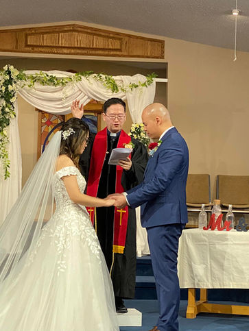Pastor Paul officiating a wedding for Mr. & Mrs. Ho.