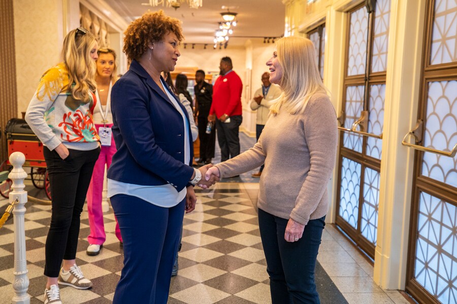 Two cast members shake hands in the Main Street Opera House lobby