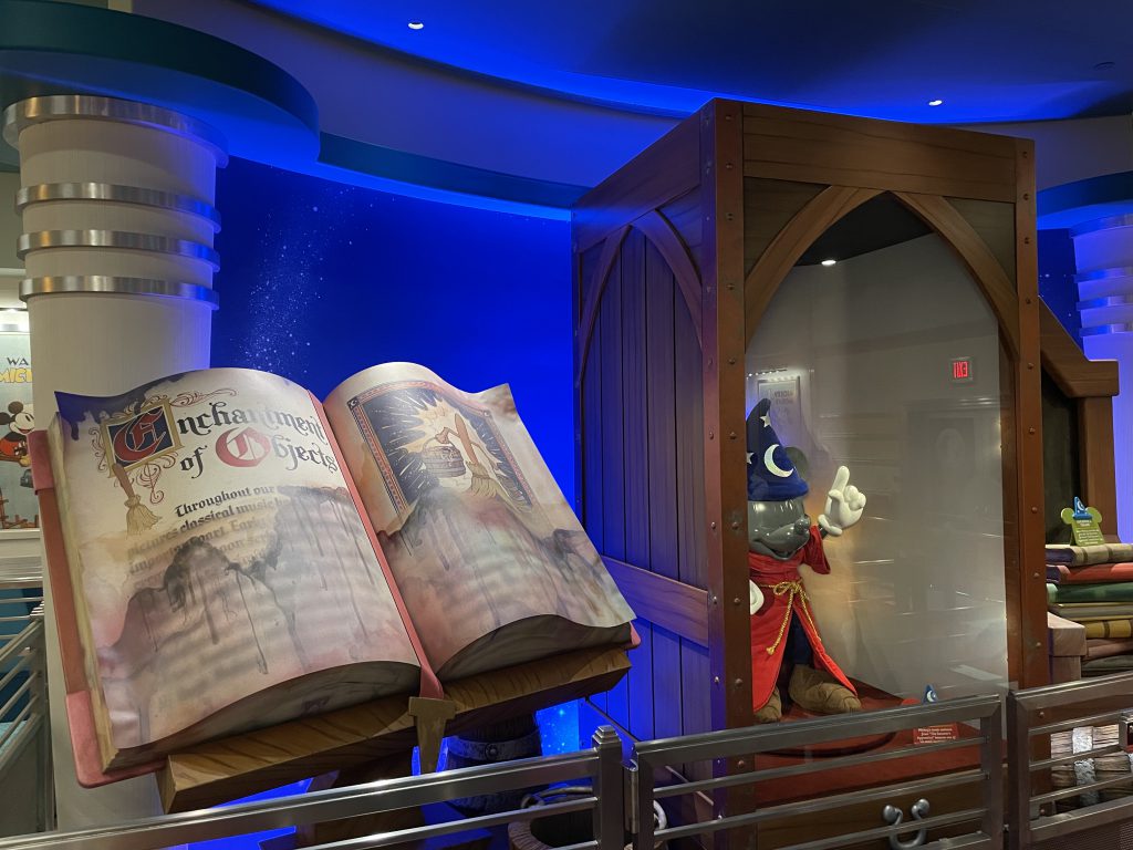 Mickey Mouse sorcerers apprentice cartoon outfit and book props located inside the queue for Mickey and Minnie's Runaway Railway at Disneyland Park located within Mickey's Toontown.
