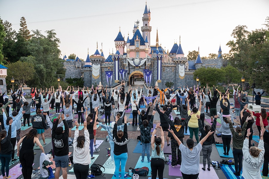 Cast Members do yoga in front of Sleeping Beauty Castle, Disneyland