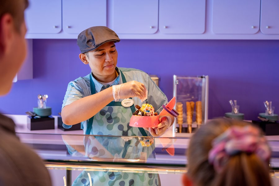 Cast member assembling dessert for customers