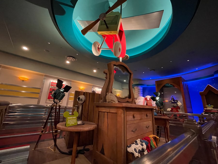 Collection of Mickey Mouse cartoon short props located inside the queue for Mickey and Minnie's Runaway Railway. Notably an airplane from 1928 Plane Crazy and Lonesome Ghosts 1937 mirror dresser. The ride is located in Disneyland Park at Mickey's Toontown.