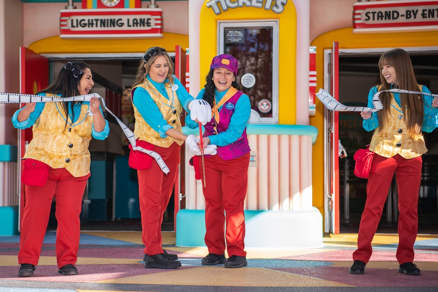 Cast members cut a grand opening ribbon in front of the attraction