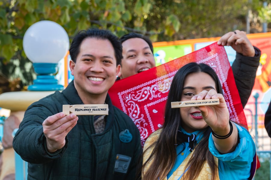 Opening team cast members hold up their commemorative train whistles