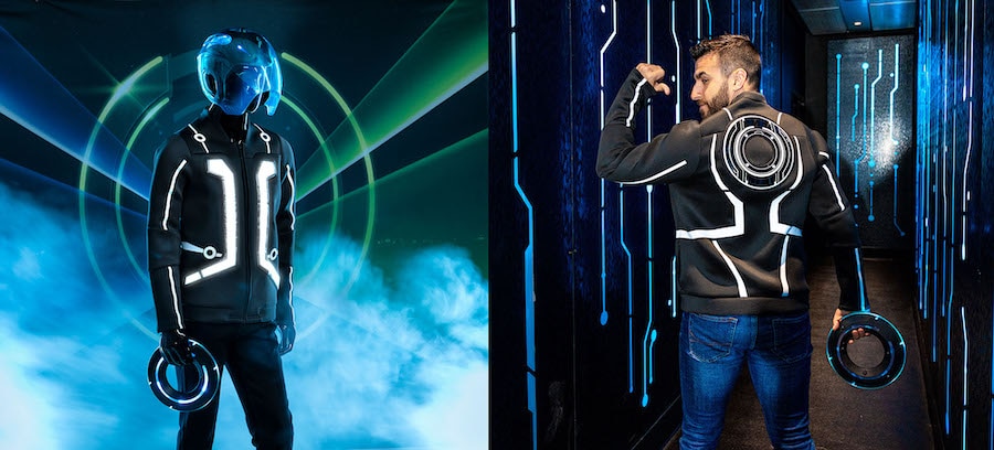 Left image: Mannequin dressed in Grid-themed apparel including a helmet and holdingan Identity Disc. Right: Person wearing Grid-themed apparel and holding an Identity Disc in ahallway that resembles a circuit board.