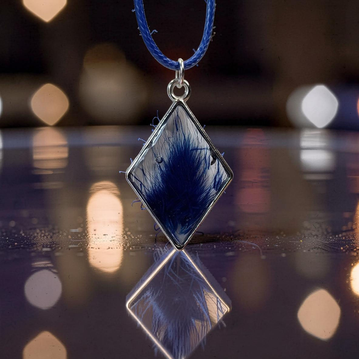Blue diamond pendant with feathery design, reflected