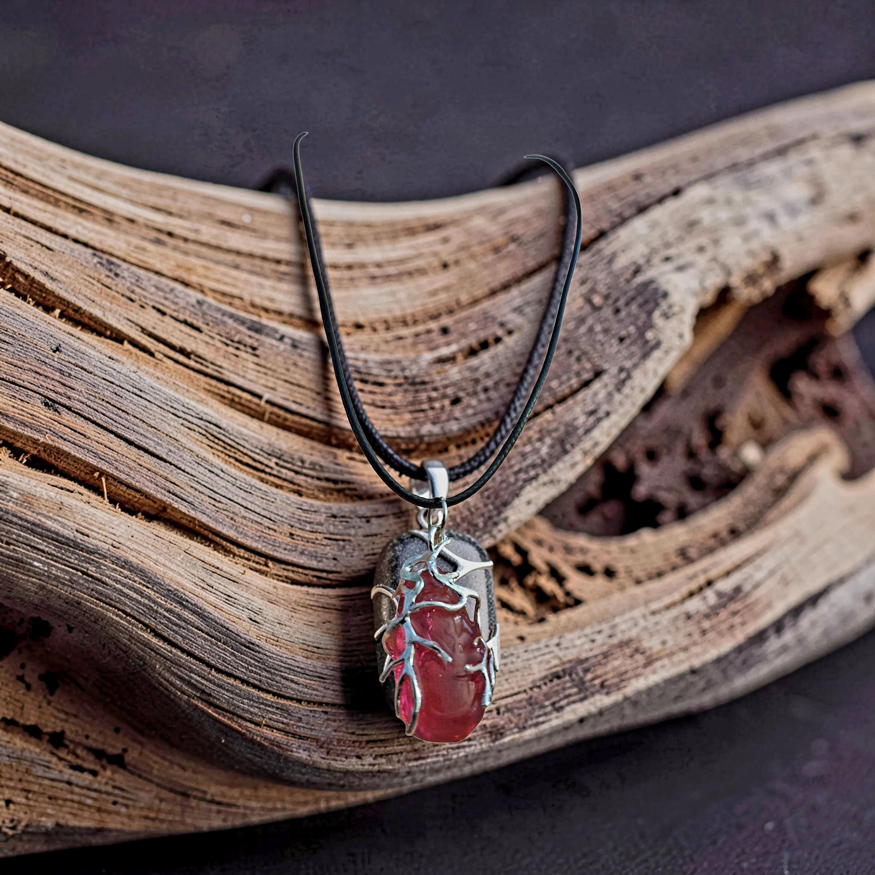 Red stone pendant with botanical silver setting on driftwood