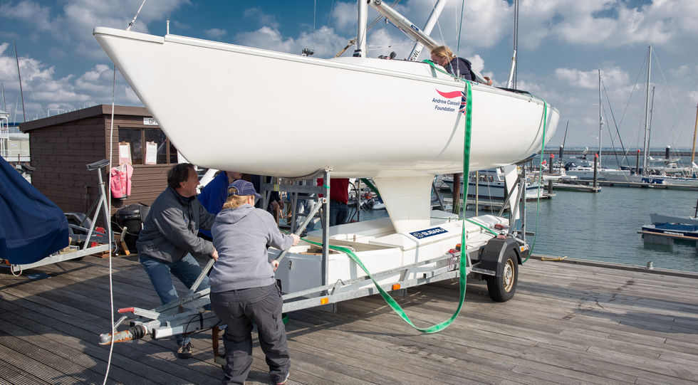 A group of people helping move a boat on a trailer