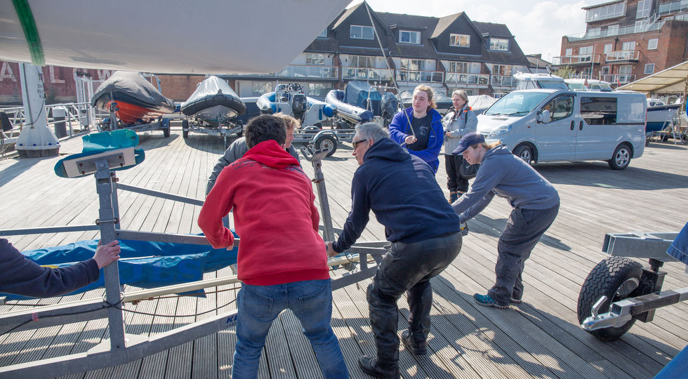 A group of people helping move a boat on a trailer