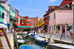 Boats parked in canal in Burano Italy in the Venetian Islands.