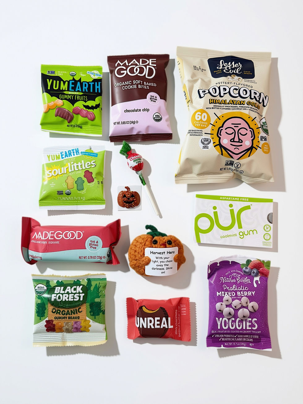 Halloween care package contents with organic snacks, treats, gum, lollipop and handmade pumpkin comfort character