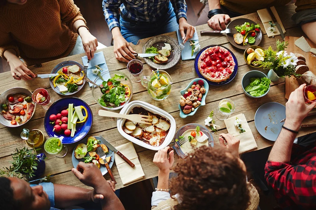 group of people socialising while eating lots of food
