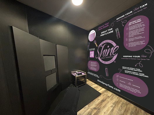 Custom spray tan room at SHINE Studios Miracle Hills featuring prep and care instructions on the wall