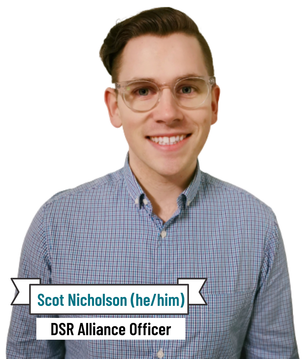 [Image ID: Scot, a White male with light skin, blue eyes and brown hair. He is smiling brightly, wearing clear framed circular glasses and a blue checkered business shirt. The image background is plain white. The image is taken from the elbows up]