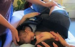 A mother and baby receiving Reiki on a table at the office at Healing Heart Reiki.