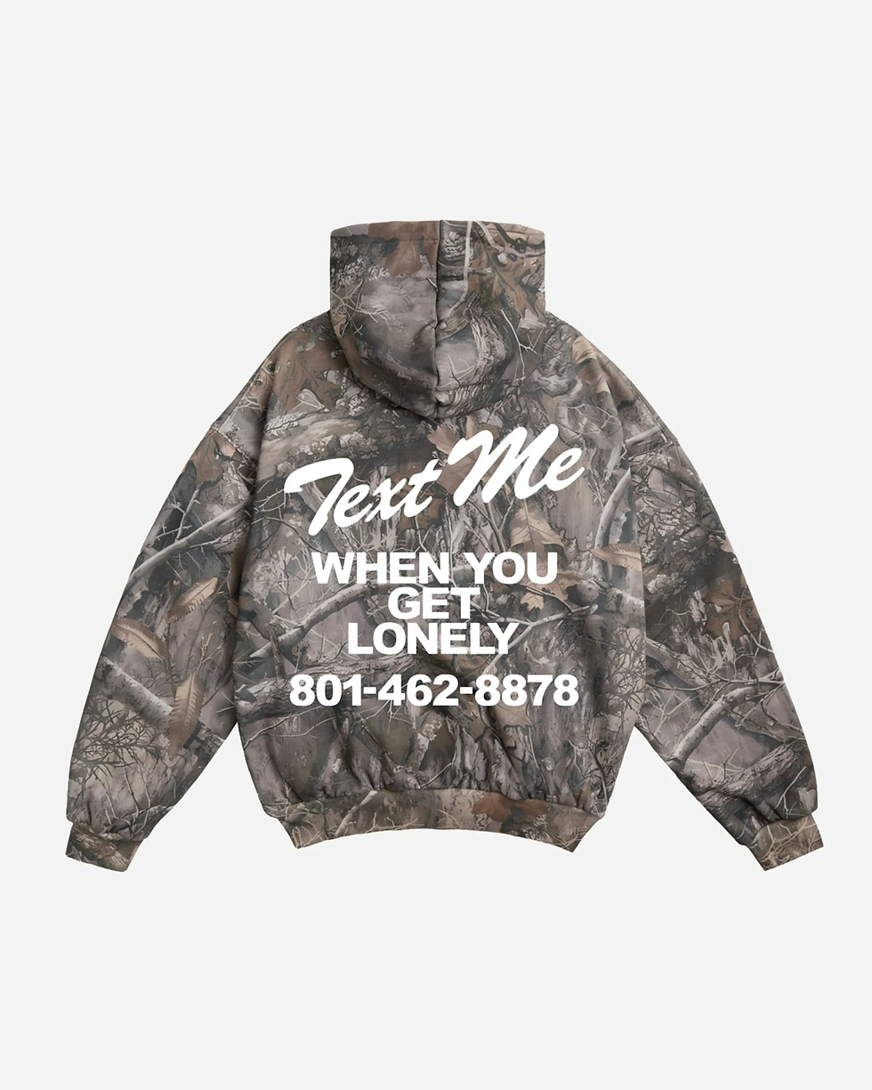 Camo hoodie with a Text Me When You Get Lonely graphic