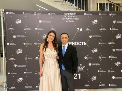 Loran Jacobs standing in formal attire in front of the official ceremony backdrop at the Kremlin.