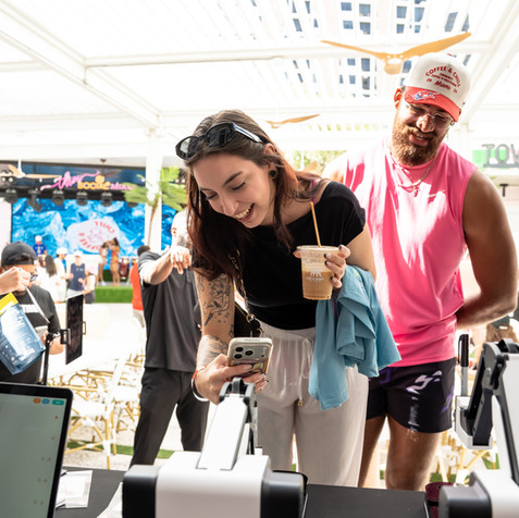 Guests instantly sharing digital photos from a sleek selfie station at a South Beach corporate activation.