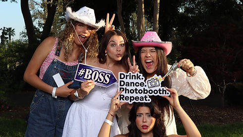 Women in cowboy hats pose with a 'Photobooth' sign from a Photo Booth Rental Newark DE.