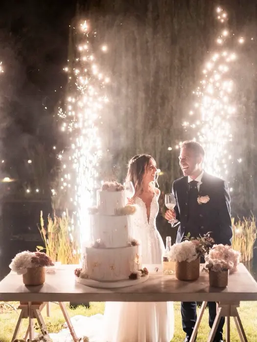  Sposi felici tagliano la torta tra spettacolari fontane di luce scintillanti.