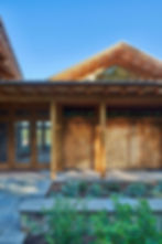 Timber frame exterior with firewood storage at Meadow Creek Farm custom home by Omnibuild Construction Floyd VA