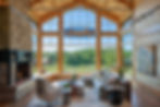 Stone and timber frame sunroom with panoramic mountain views at Meadow Creek Farm by Omnibuild Construction