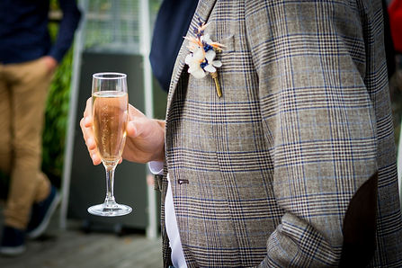 Une personne tient une cope de champagne durant le vin d'honneur.