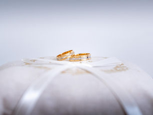 Photographe de mariage à Rennes. Les alliances posées sur un coussin blanc