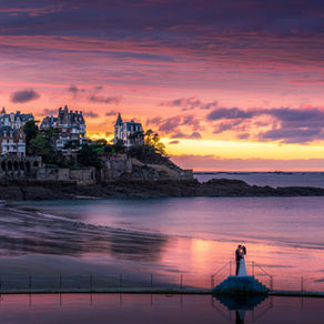 Photographe de mariage à Dinard. Couple de marié s'embrassant au coucher du soleil sur la plage de Dinard durant un reportage de mariage