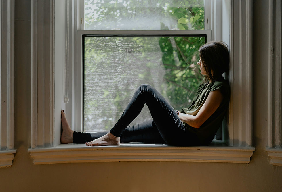 Woman sitting by a window looking outside