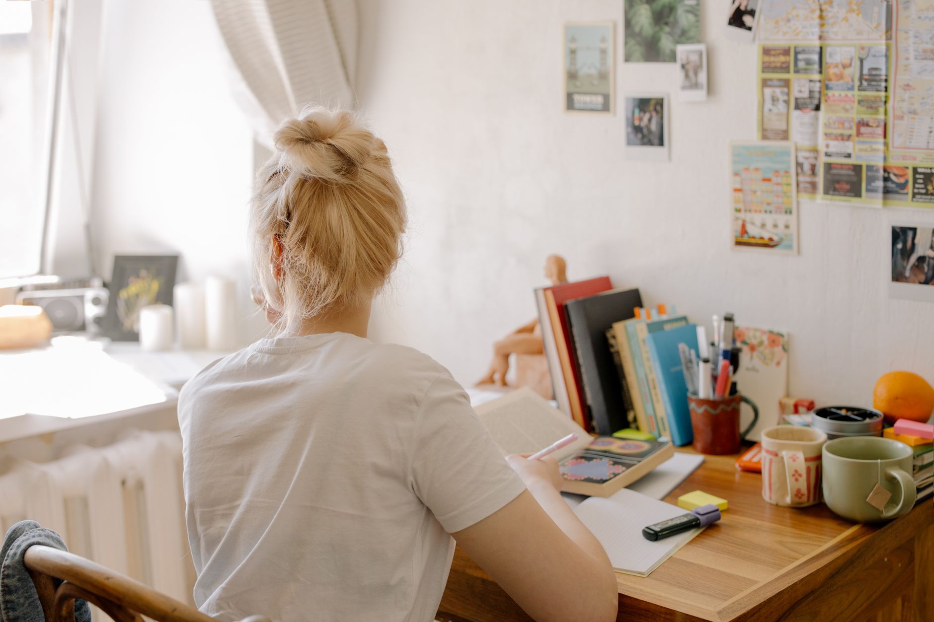 Student studying at a desk with notes and laptop