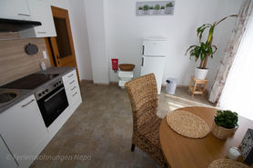 Moderne Ferienwohnungsküche mit Tisch und Stühlen