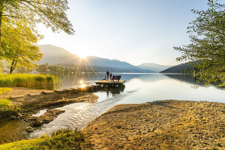 Sonnenaufgang am See: Familie am Steg