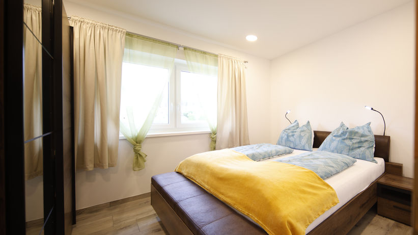 Gemütliches Schlafzimmer mit Doppelbett und Kleiderschrank