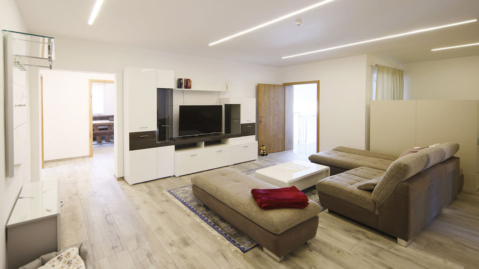 Modern eingerichtete Ferienwohnung: Wohnzimmer mit TV und Sofa