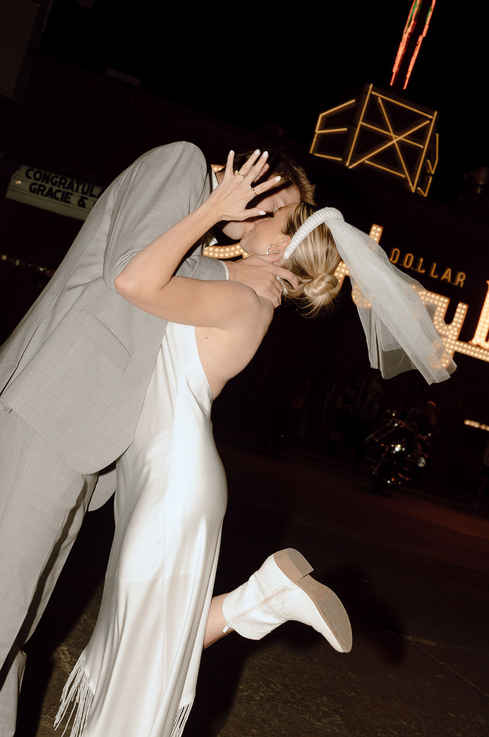 Bride showing off ring while kissing groom after elopement Cowboy Bar Jackson Hole Wyoming
