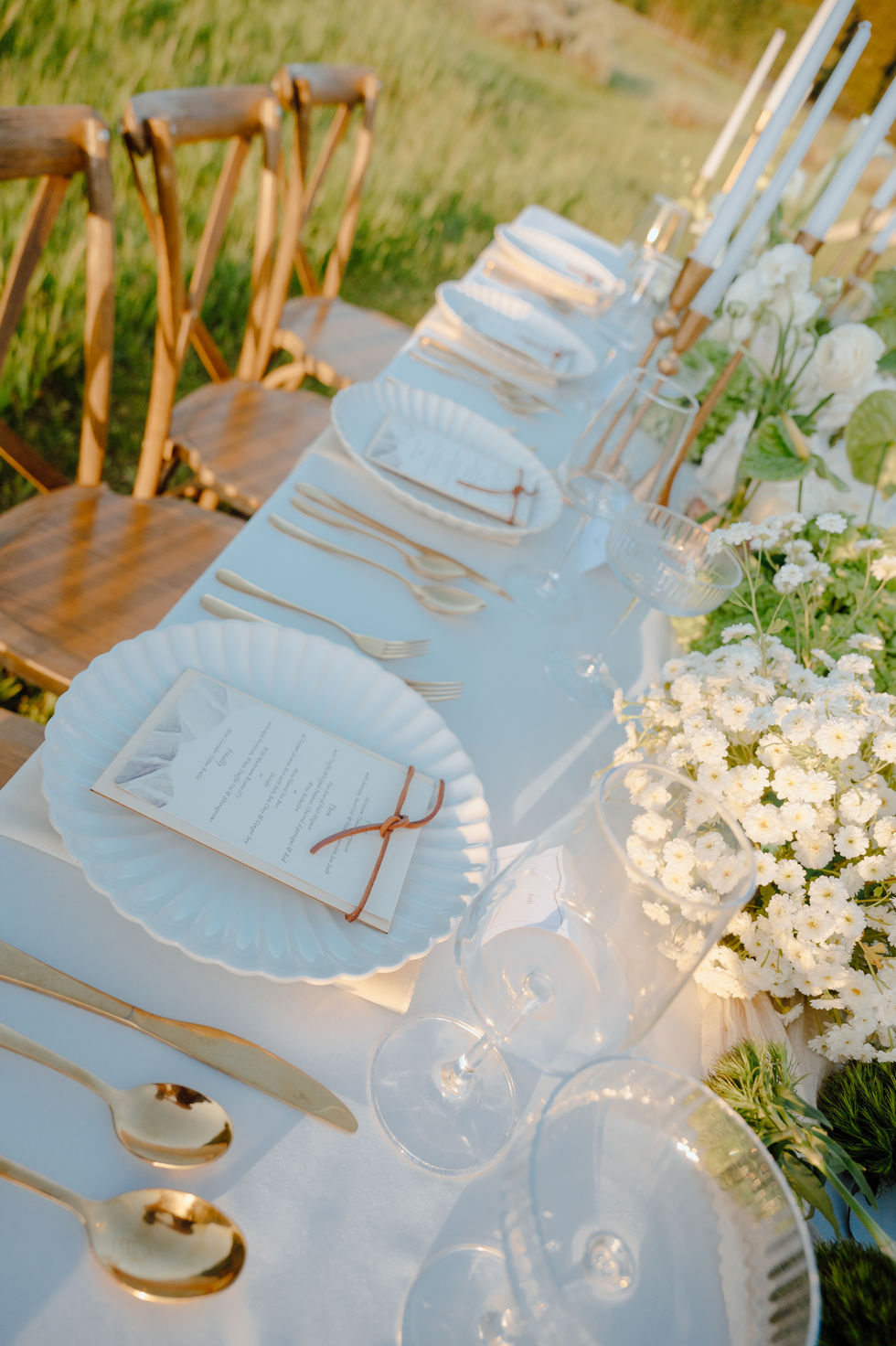 Elegant outdoor table setting with white flowers.